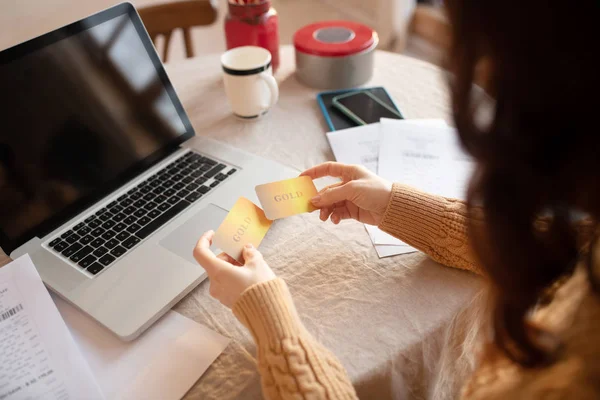 Mujer joven de pelo largo en suéter con una tarjeta de crédito — Foto de Stock