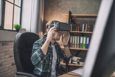 Yeni bir VR kulaklık takan yakışıklı adam.