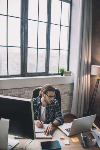 Joven barbudo con anteojos trabajando en el proyecto — Foto de Stock