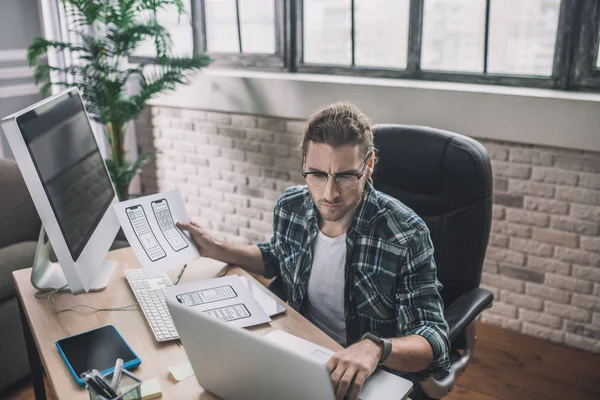 Junger Mann mit Brille sitzt am Schreibtisch — Stockfoto