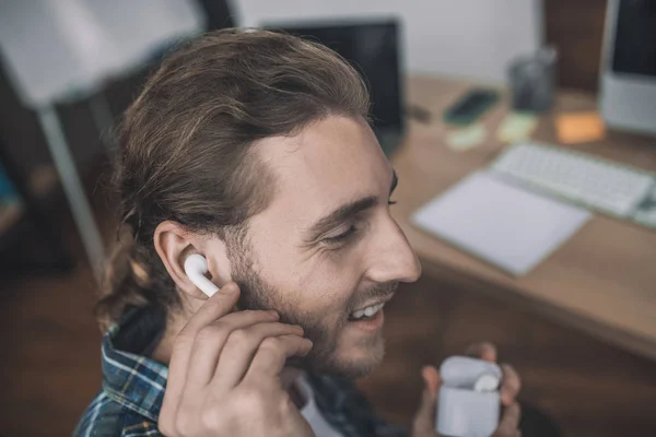 Schöner junger Mann mit bequemen drahtlosen Kopfhörern — Stockfoto