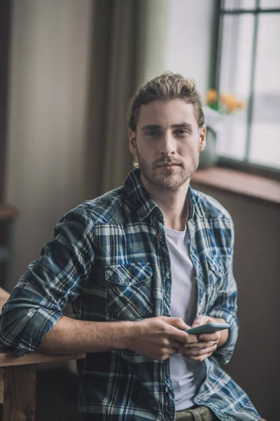 Active and energetic man holding his smartphone