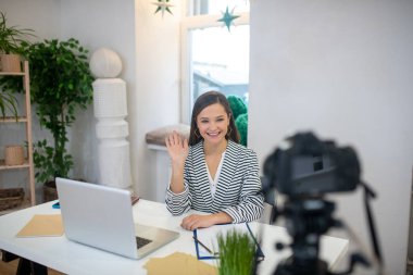 Joyful happy woman greeting her blog viewers