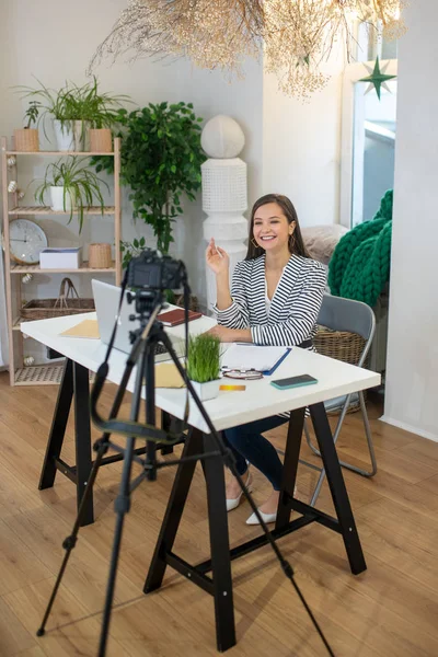 Positive delighted woman recording a video on camera