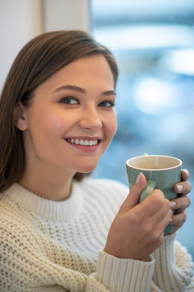 Encantada joven disfrutando de su delicioso café — Foto de Stock
