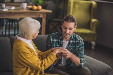 Gri saçlı yaşlı bayan oğluyla kendini çok iyi hissediyor.