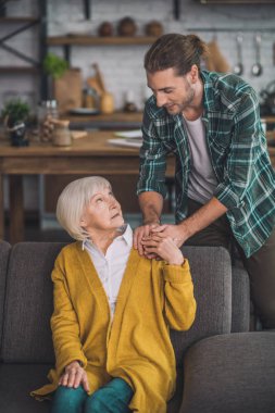 Gri saçlı yaşlı bayan oğluyla iyi hissediyor.