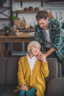 Gri saçlı yaşlı kadın oğluyla huzur içinde.