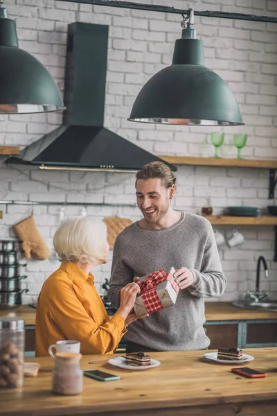 Elegante, goed uitziende, grijsharige vrouw met een gelukkige geschenkdoos — Stockfoto