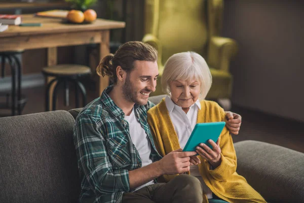 Mujer anciana de pelo gris mirando el comprimido — Foto de Stock