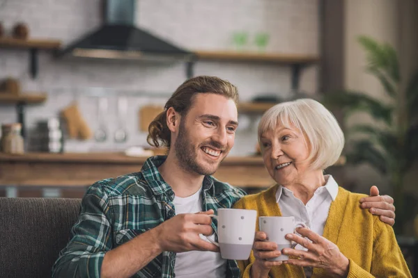 Grauhaarige ältere Frau beim morgendlichen Kaffee mit Sohn — Stockfoto