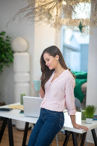 Pretty young woman standing with a cup of tea — Stock Photo, Image