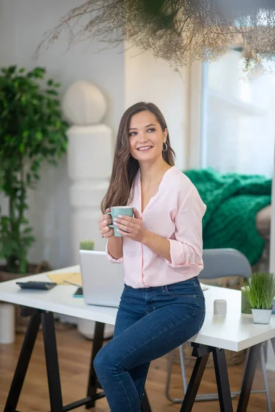 Beautiful happy woman standing near the table — 스톡 사진