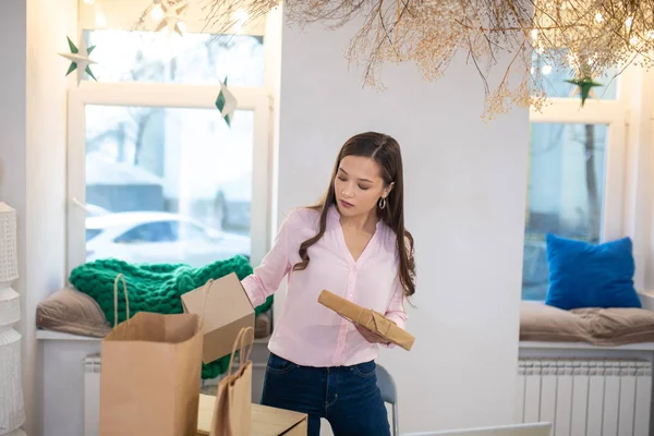 Mujer joven agradable sosteniendo una caja de regalo — Foto de Stock