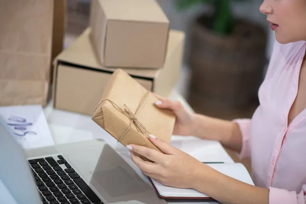 Primer plano de un paquete envuelto en manos femeninas — Foto de Stock