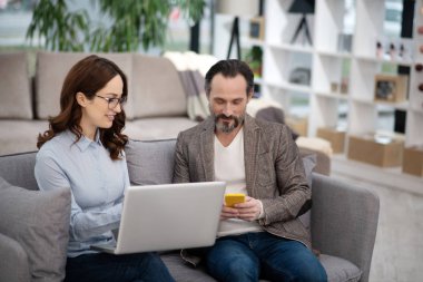 Mobilya dükkanında yönetici müşteriye yeni modeller gösteriyor