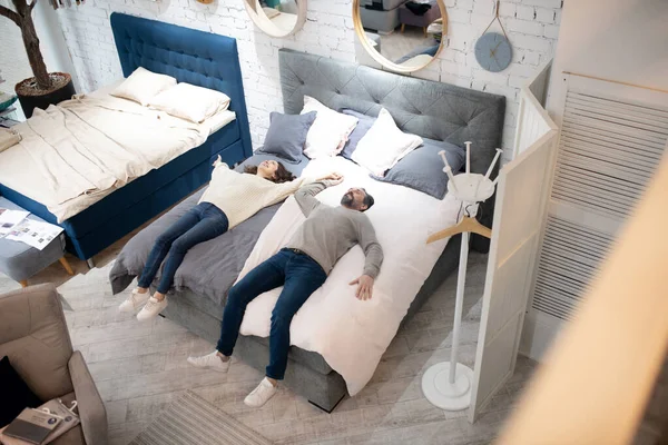 男人和女人躺在床上家具沙龙上 — 图库照片