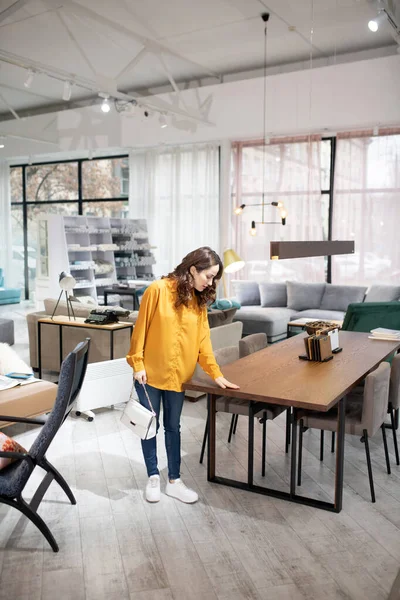 Mujer bonita de pelo largo tocando la superficie de la mesa — Foto de Stock