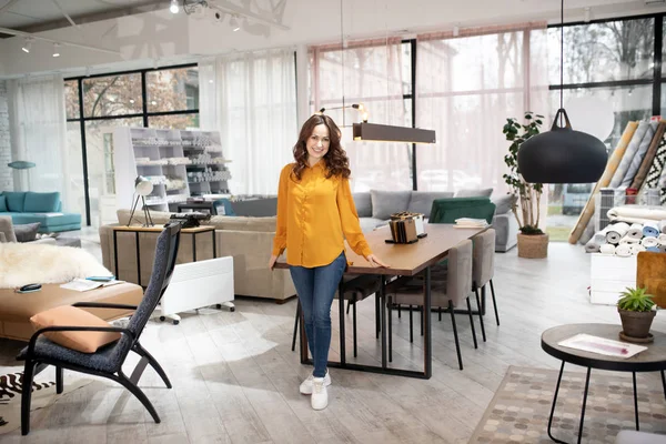 Long-haired pretty woman standing near the table — Stock Photo, Image