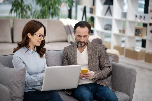 Gerente en tienda de muebles mostrando nuevos modelos al cliente — Foto de Stock