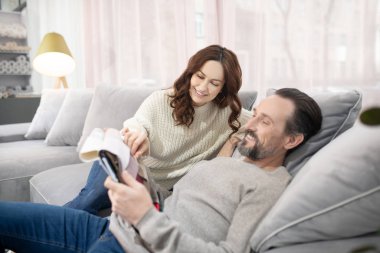 Kadın ve erkek kanepede oturmuş kumaş seçiyorlar.