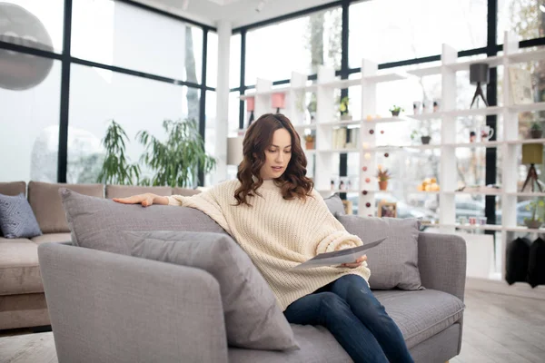 Femme aux cheveux bruns en chemise blanche et jeans concentrés — Photo