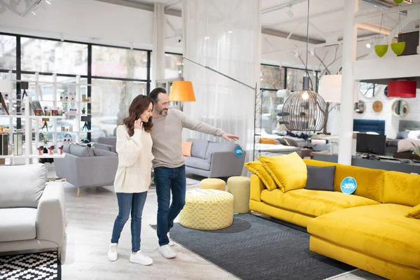 Two people discussing furniture models in a modern furniture shop — 스톡 사진