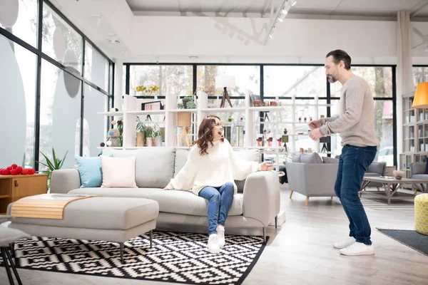 Casal discutindo modelos de móveis em uma loja de móveis moderna — Fotografia de Stock