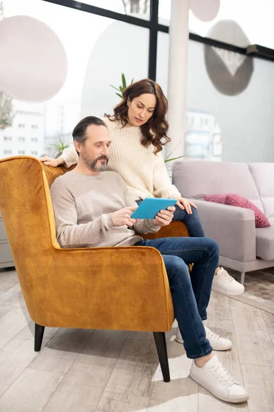 Pareja pasando su tiempo en el salón de muebles buscando modelos en línea —  Fotos de Stock