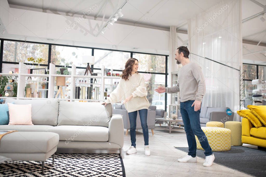 Man and woman discussing furniture models in a modern furniture shop