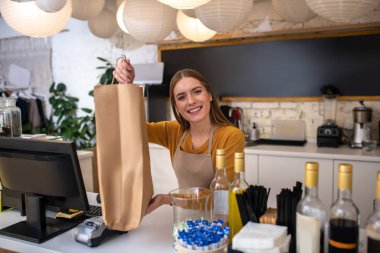 Gülümseyen kafe çalışanı bir müşteri için sipariş vermiş.