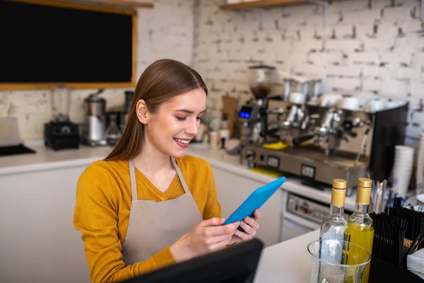 彼女の仕事のためにタブレットを使用して笑顔のカフェの従業員 — ストック写真