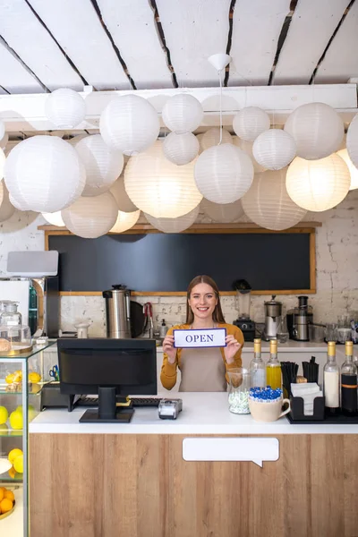Mujer joven sonriente abriendo una nueva cafetería — Foto de Stock