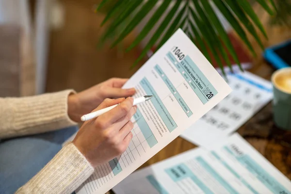 Mujer sosteniendo el papel para contar los gastos fiscales — Foto de Stock