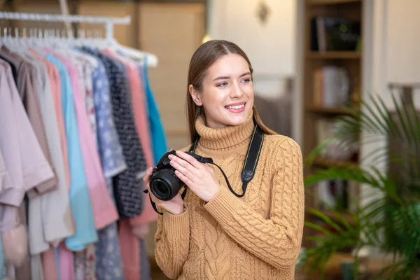 Mosolygó nő kezében egy fényképezőgép, miközben csinál egy fotózást — Stock Fotó