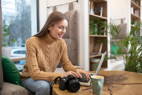 Photographer uploading pictures from the camera on her computer — Stock Photo, Image