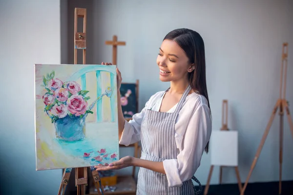 Jovem artista feliz mostrando-lhe sua pintura — Fotografia de Stock
