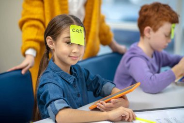 Okulda teknoloji kullanan küçük bir kız.