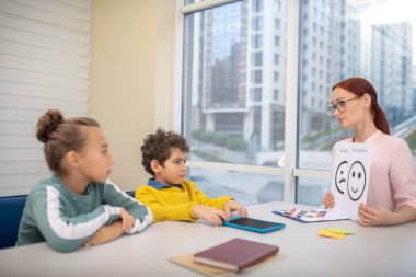 Genç öğretmen ders sırasında emoji resimlerini kullanıyor.