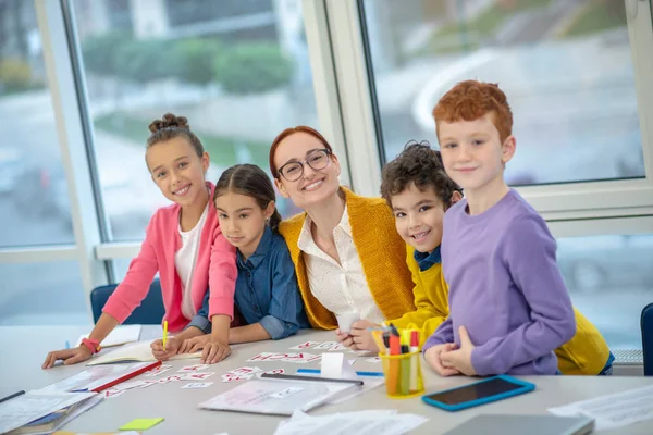 Smiling teacher having fun with children during the lesson — Stock Photo, Image