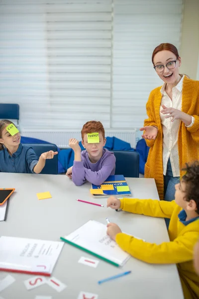 Active school teacher playing with elementary school children — Stock Photo, Image