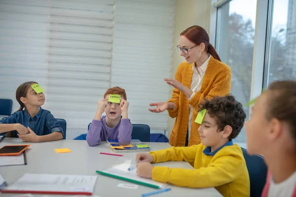 Öğretmen çocukların kelime oyunu oynamasına yardım ediyor