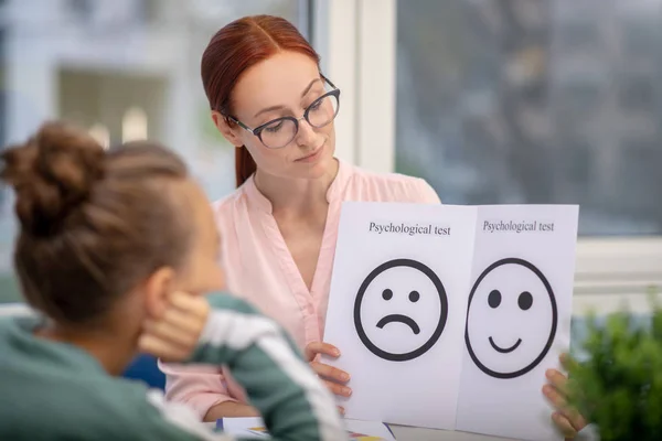 Skoncentrowany nauczyciel pokazujący jej test psychologiczny — Zdjęcie stockowe