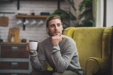 Koltukta oturan sakallı yakışıklı adam.