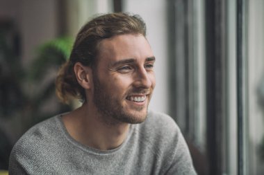 Gri sakallı yakışıklı adam mutlu görünüyor.