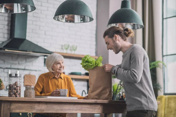 Jongeman die de groene verpakking opent — Stockfoto