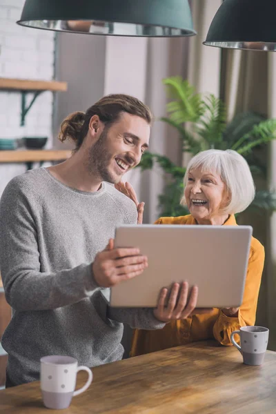 Grey-haired mamá y su hijo discutir algo animado en la cocina — Foto de Stock