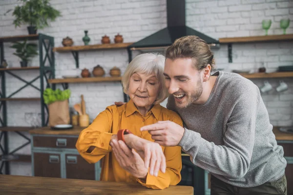 Guapa anciana en amarillo sintiéndose genial con su hijo — Foto de Stock