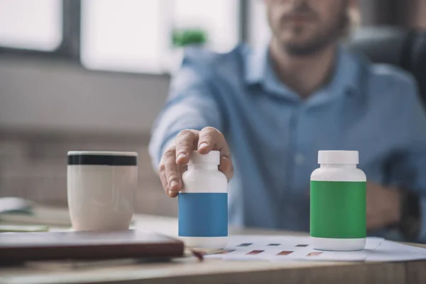 Hombre barbudo con camisa azul tomando un frasco con pastillas — Foto de Stock