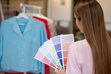 Designer in the process of choosing a color combination. clipart